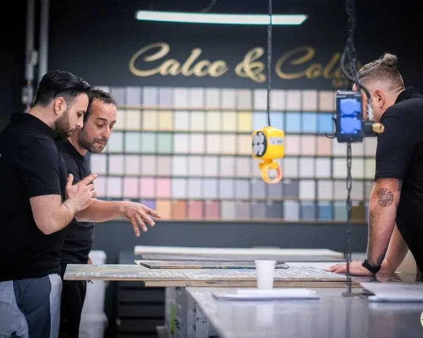 Drei Mitarbeiter von Eigenwerk stimmen an der Farbmusterwand «Calce & Colore» einen Farbton ab