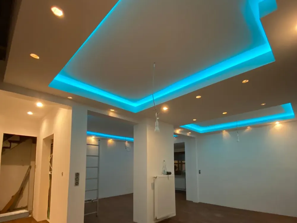 Fertiger Raum mit Holzboden und umlaufendem blauem Lichtband in der Deckenvoute