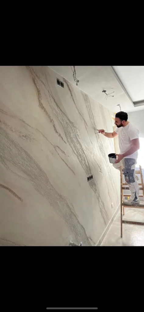 Standbild aus einem Video: Handwerker spachtelt eine helle Marmoroptik