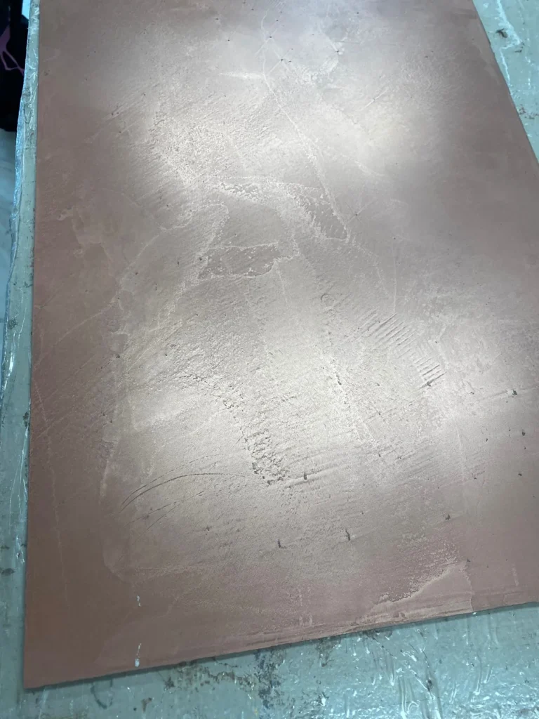Metallisch glänzende Fläche mit Wolkenbildung